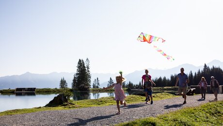 Der alpine Högsee in der Familienregion Serfaus-Fiss-Ladis in Tirol lädt zum Baden, Sonnenbaden und Spielen ein | © danielzangerl.com